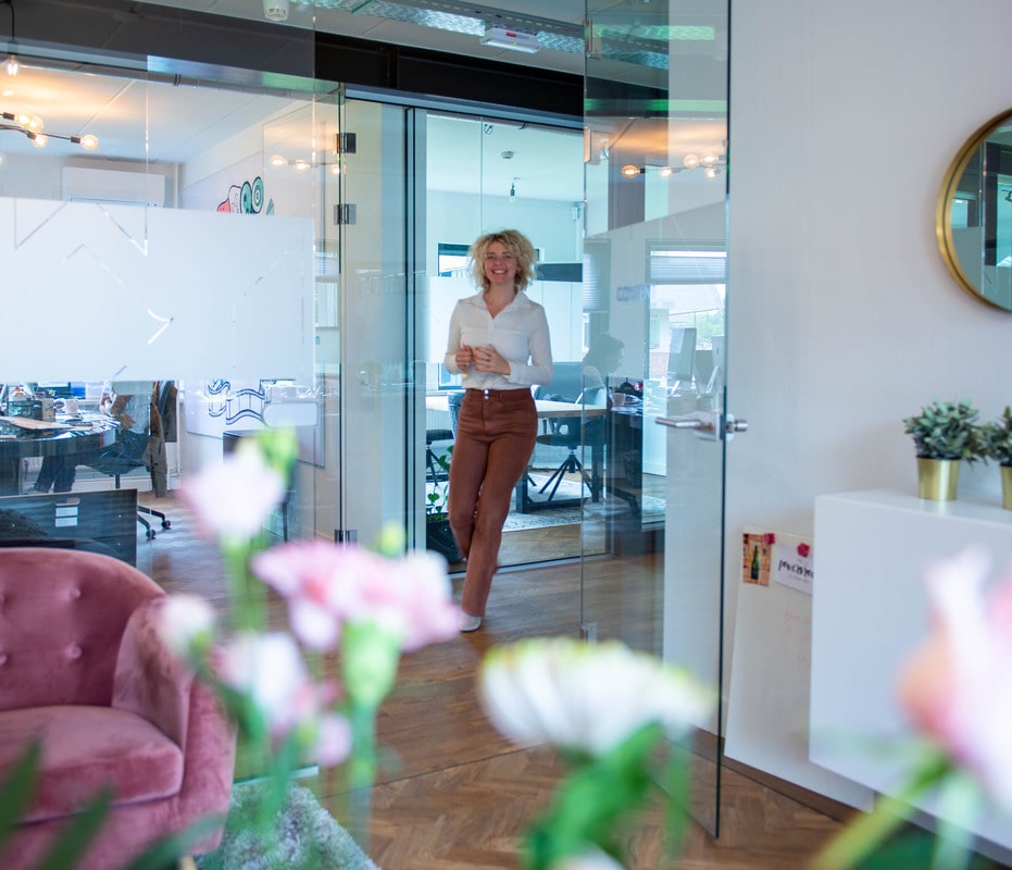 Corien bij een glazen kantoorwand